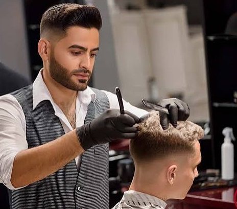 Stylist shaping a fade with a comb and clippers