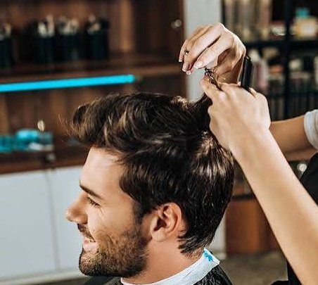 Stylist scissor cutting a client's pompadour