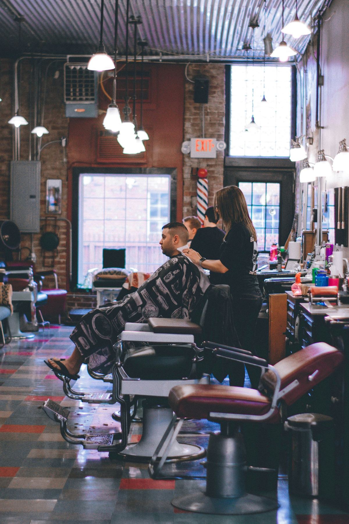 Aura Barbershop interior with styling chairs and arched mirrors